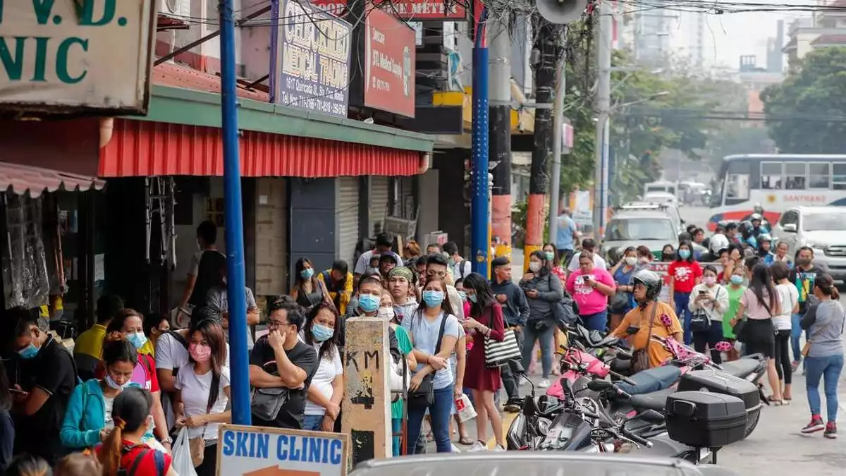La gente hace cola para comprar máscaras en una tienda de suministros médicos en Manila (Filipinas).