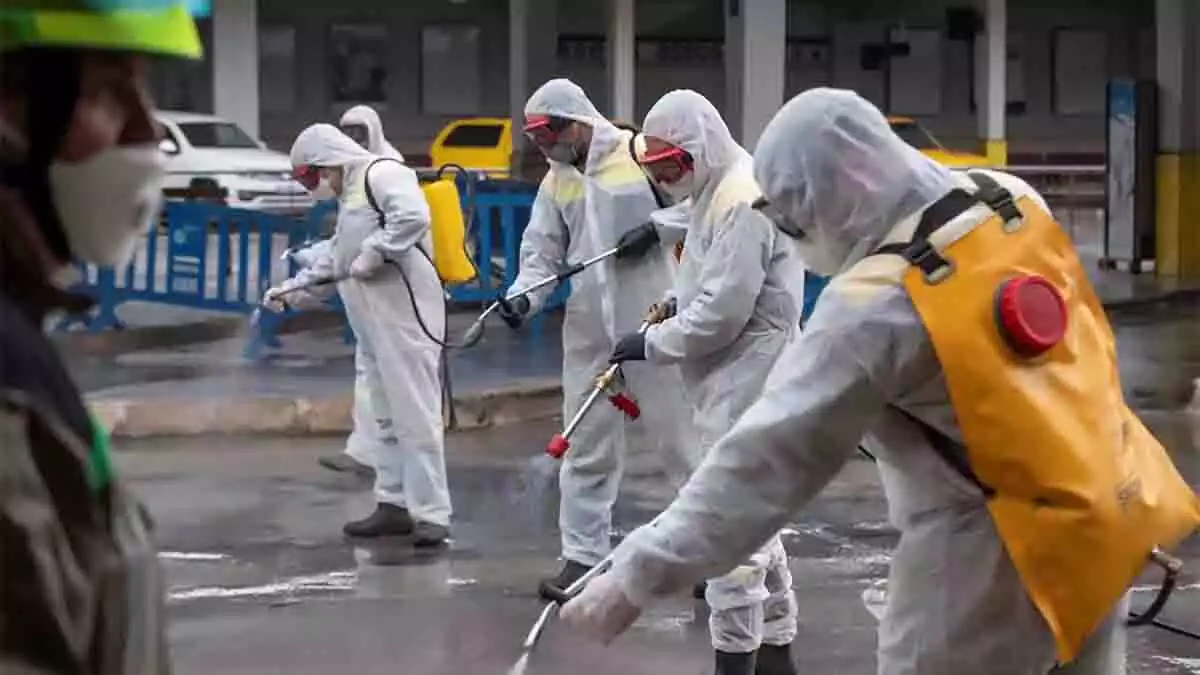 Agentes medioambientales fumigan una calle durante la crisis del coronavirus