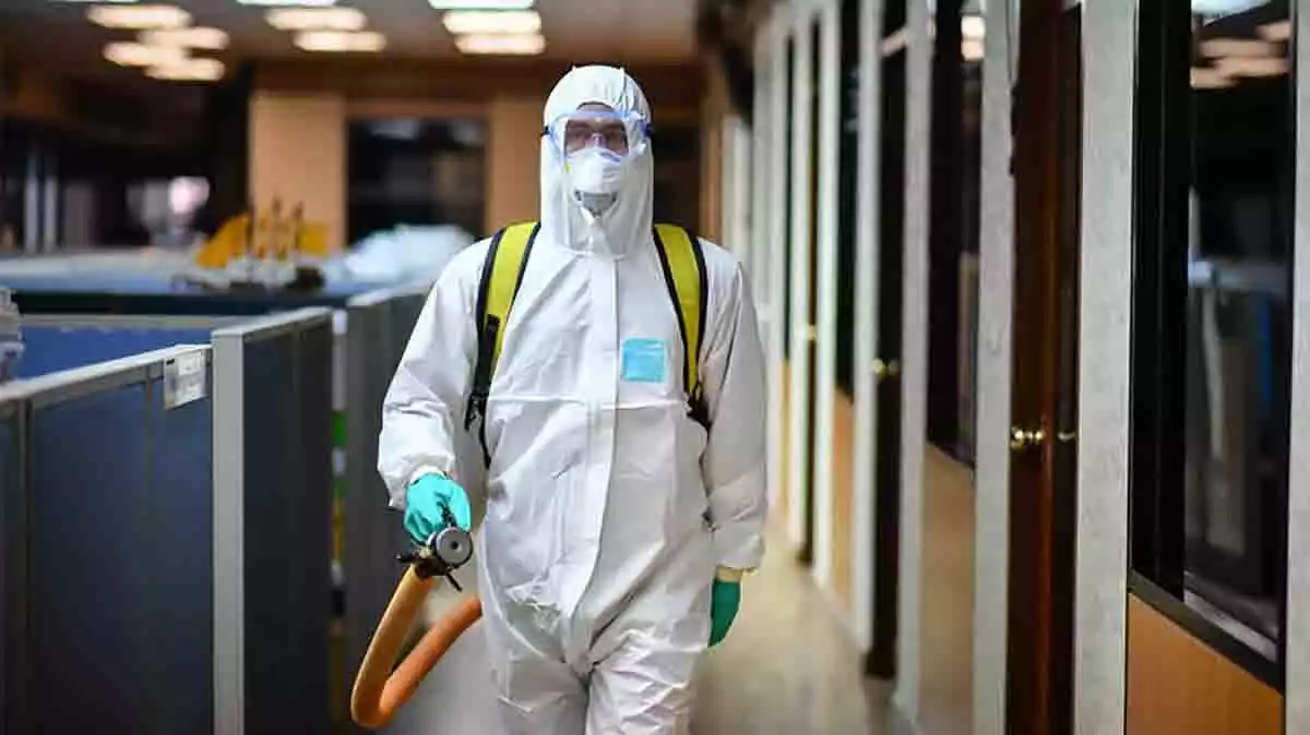 Sanitario desinfectando una sala durante la crisis del coronavirus