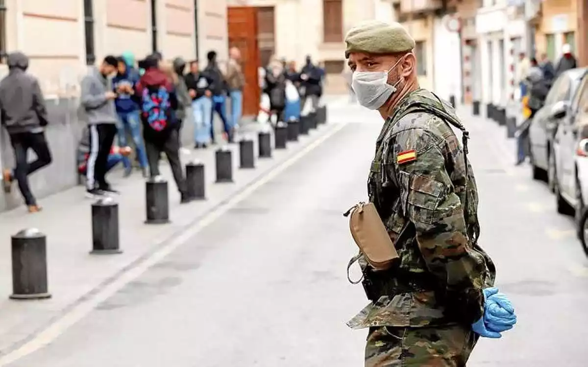 Imagen de un soldado con una mascarilla a pie de calle