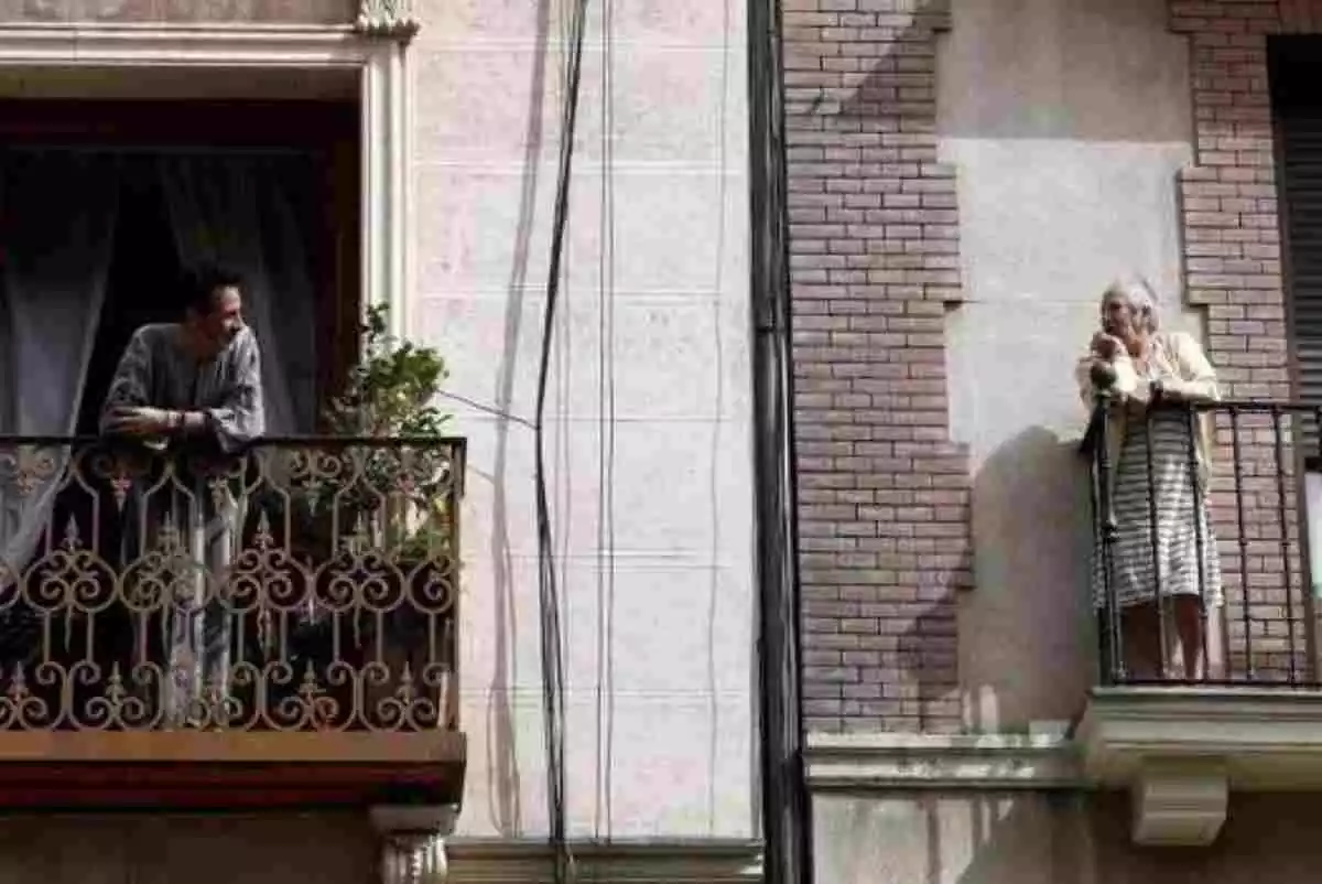 Vecinos en los balcones durante el confinamiento por el Coronavirus en España
