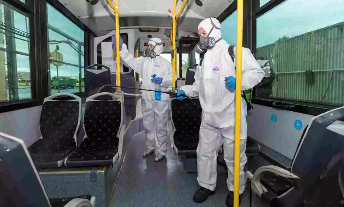 Dos sanitarios desinfectando un autobús