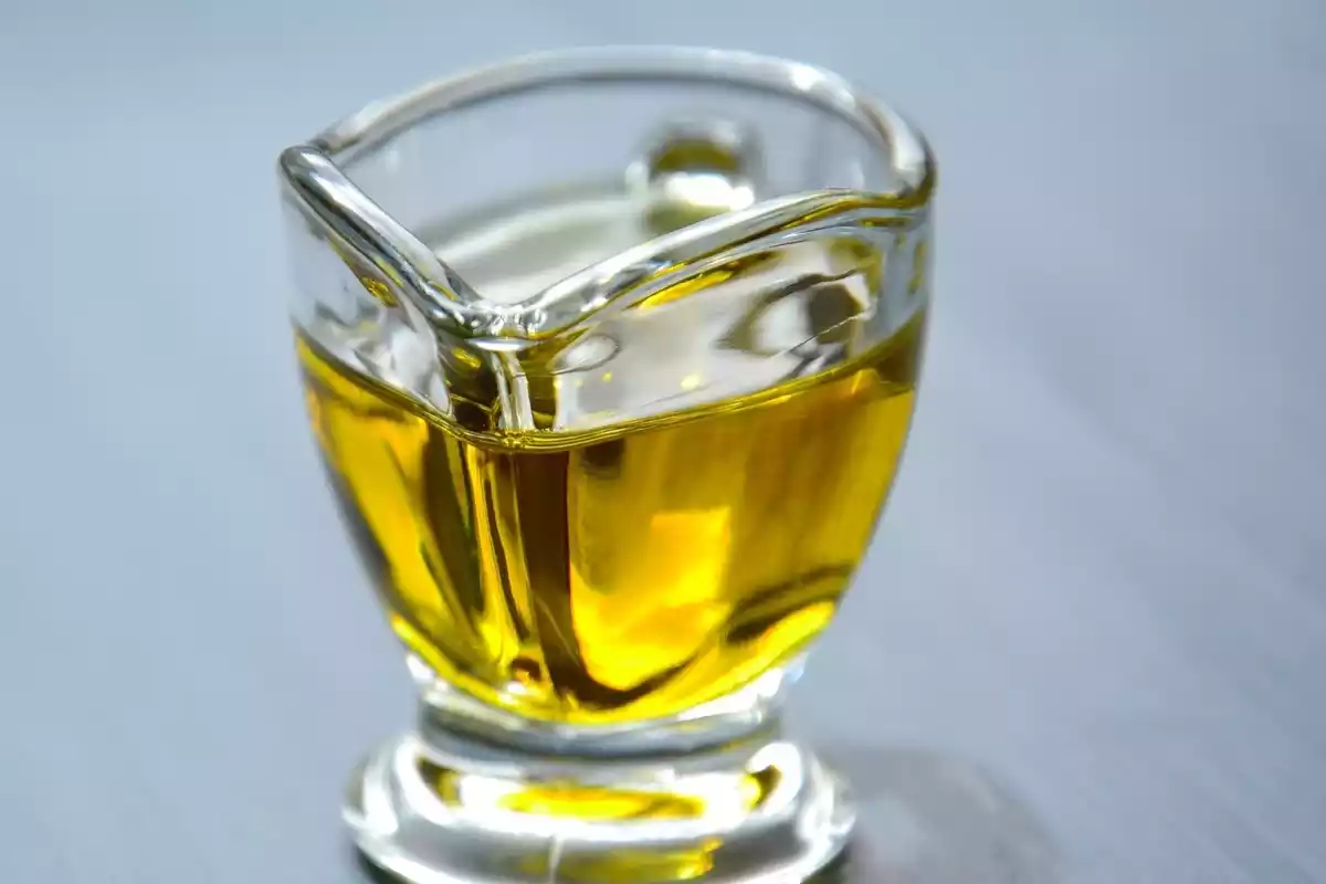 Un vaso lleno de aceite de oliva de color amarillo
