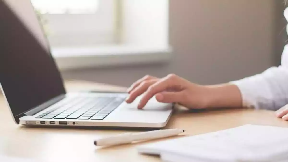 Mujer utilizando su portátil desde su mesa de escritorio