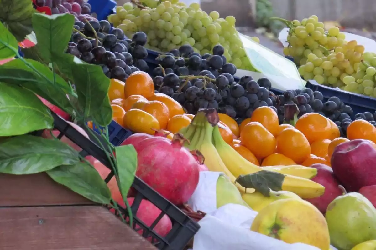 Uvas, plátanos, granadas y mandarinas en un supermercado