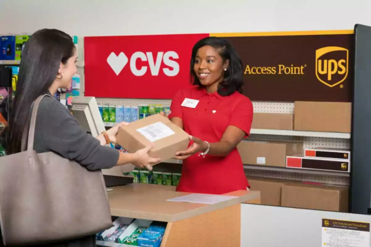 Empleada de CVS entrega un paquete a una clienta en un mostrador con cajas de UPS al fondo Empleada de CVS entrega un paquete a una clienta en un mostrador con cajas de UPS al fondo