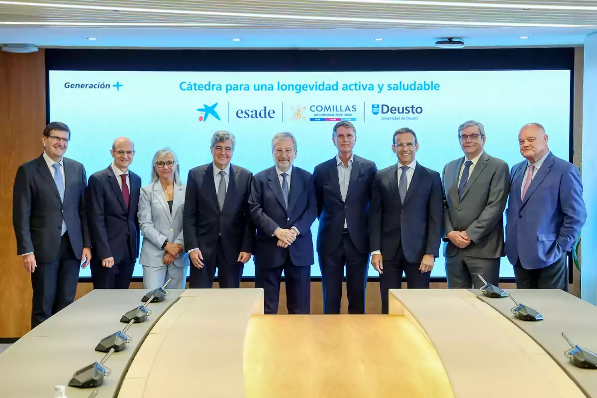 Grup de persones vestides amb vestit posant davant d’una pantalla que mostra el text Càtedra per a una longevitat activa i saludable juntament amb els logotips de diverses institucions educatives i una taula de reunions en primer pla. Grup de persones vestides amb vestit posant davant d’una pantalla que mostra el text Càtedra per a una longevitat activa i saludable juntament amb els logotips de diverses institucions educatives i una taula de reunions en primer pla.