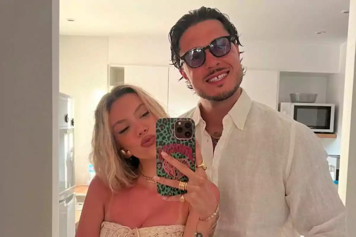 Una parella jove —formada per Alejandra Rubio i Carlo Costanzia— es fa una selfie davant d’un mirall en una cuina moderna, tots dos somriuen i porten roba clara i d’estiu. Una parella jove —formada per Alejandra Rubio i Carlo Costanzia— es fa una selfie davant d’un mirall en una cuina moderna, tots dos somriuen i porten roba clara i d’estiu.