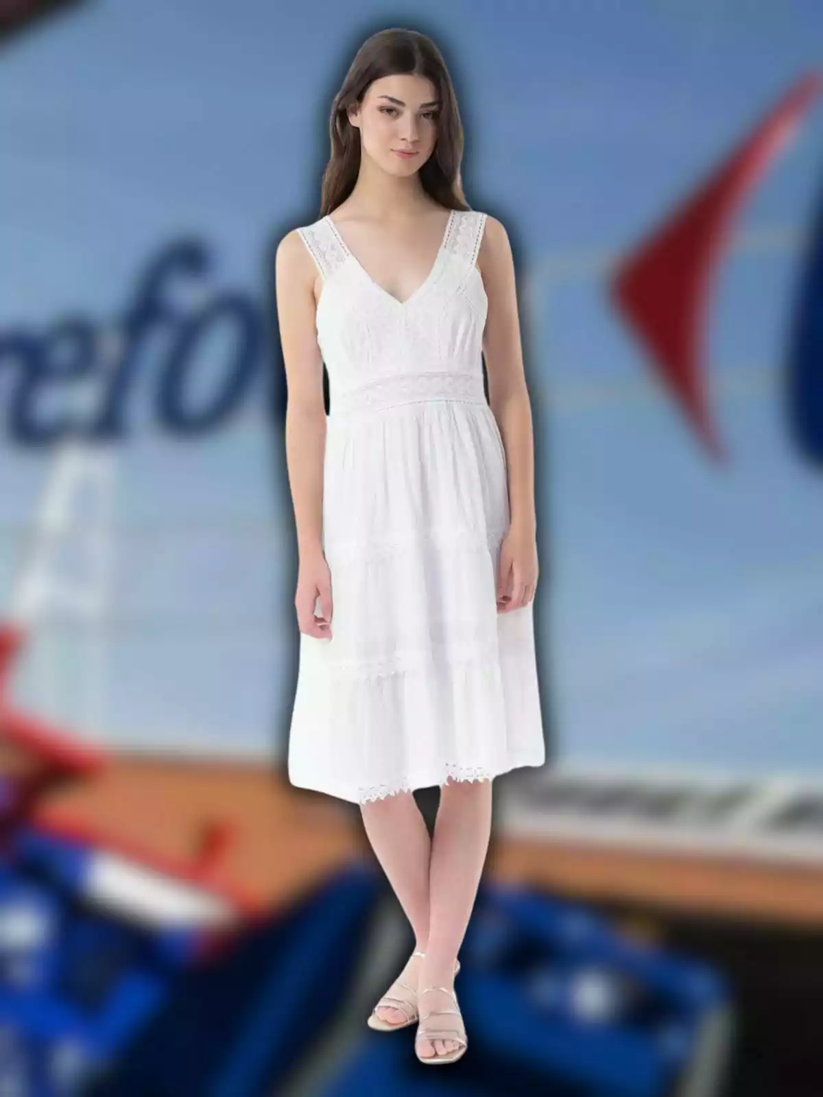 Dona jove amb vestit blanc de tirants i sandàlies posant davant d’un fons desenfocat blau i vermell Dona jove amb vestit blanc de tirants i sandàlies posant davant d’un fons desenfocat blau i vermell