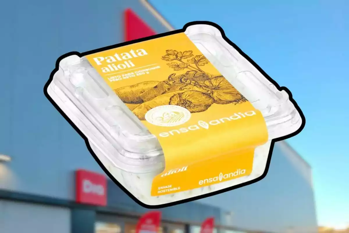 Envàs de patata allioli de la marca Ensalandia amb fons de supermercat i cel blau Envàs de patata allioli de la marca Ensalandia amb fons de supermercat i cel blau