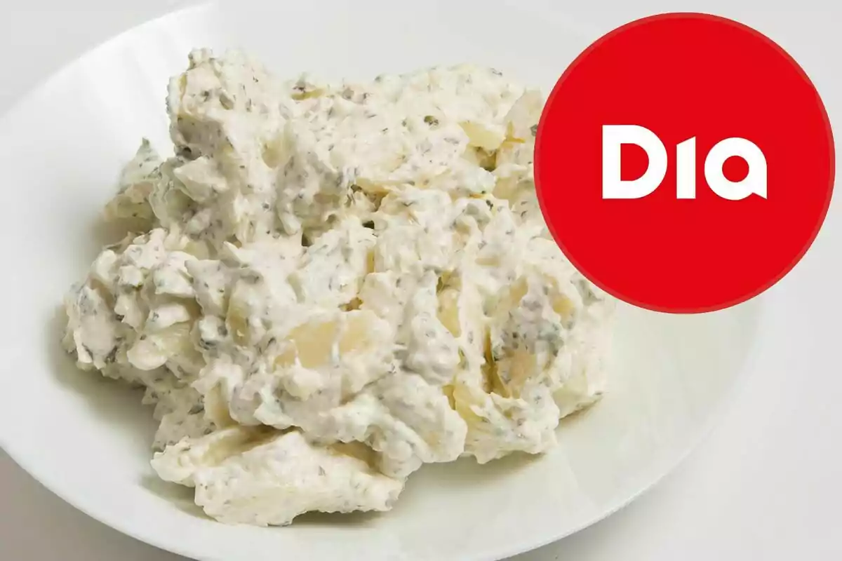 Amanida de patata amb maionesa servida en un plat blanc al costat del logotip de la marca Dia Amanida de patata amb maionesa servida en un plat blanc al costat del logotip de la marca Dia