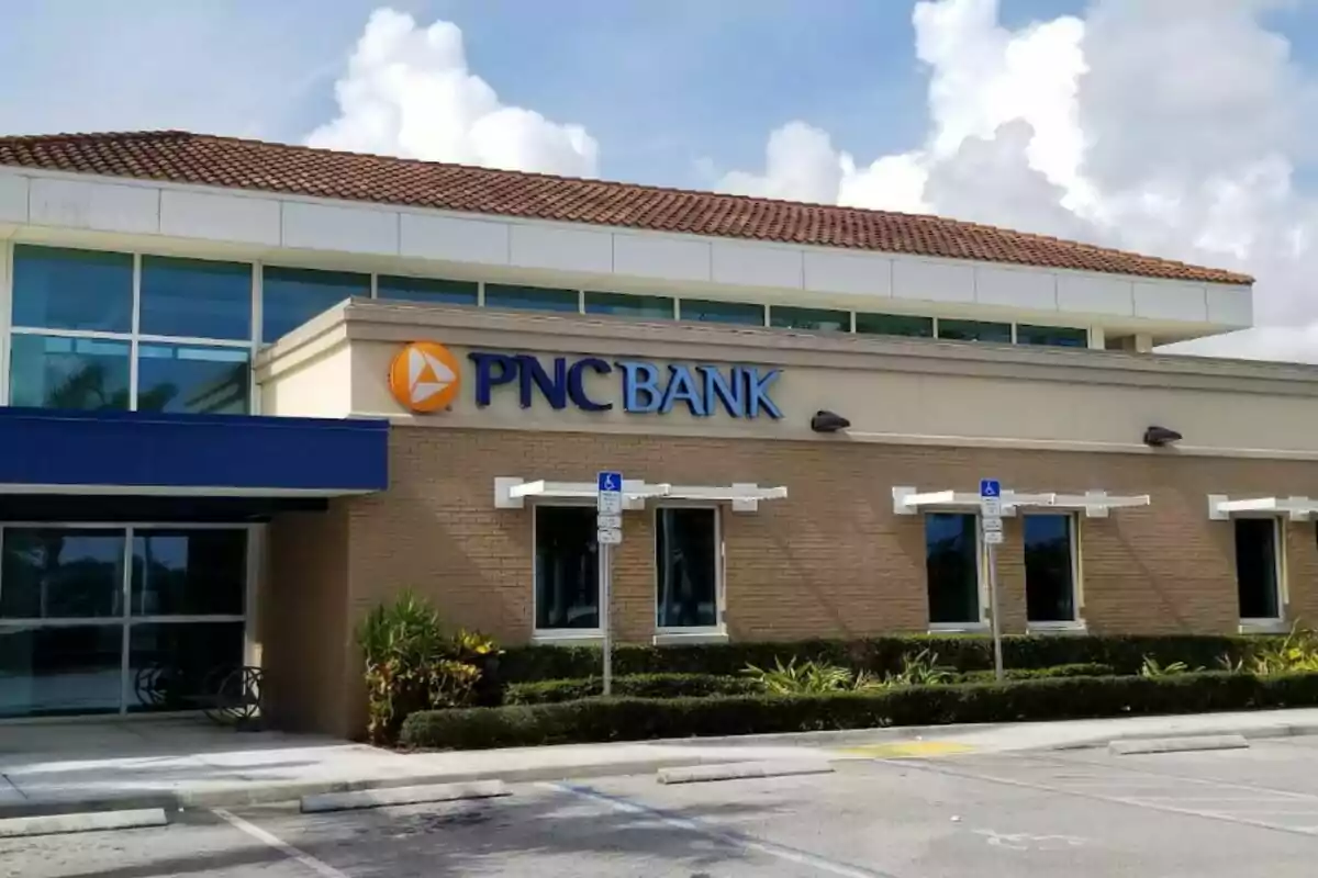 PNC bank branch with parking in front and partly cloudy sky. PNC bank branch with parking in front and partly cloudy sky.