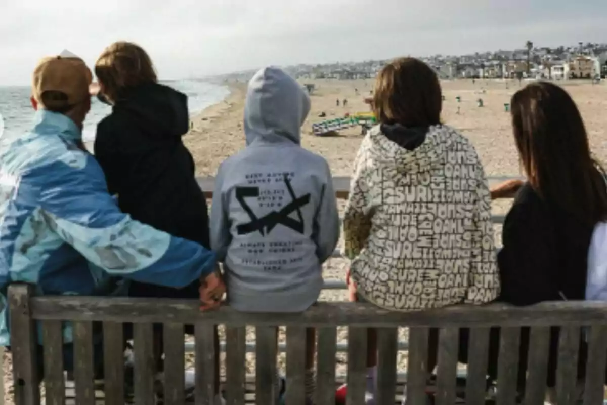 Cinc persones assegudes en un banc de fusta mirant cap a la platja —que són Pilar Rubio, Sergio Ramos i els seus tres fills— en un dia ennuvolat. Cinc persones assegudes en un banc de fusta mirant cap a la platja —que són Pilar Rubio, Sergio Ramos i els seus tres fills— en un dia ennuvolat.