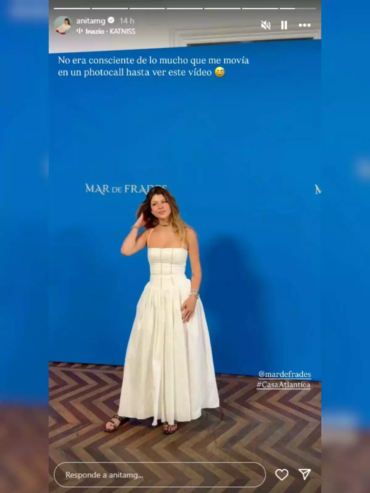 Anita Matamoros vestida amb un vestit blanc posant davant d’un fons blau amb el text 'Mar de Frades' i terra de fusta en zig-zag. Anita Matamoros vestida amb un vestit blanc posant davant d’un fons blau amb el text 'Mar de Frades' i terra de fusta en zig-zag.