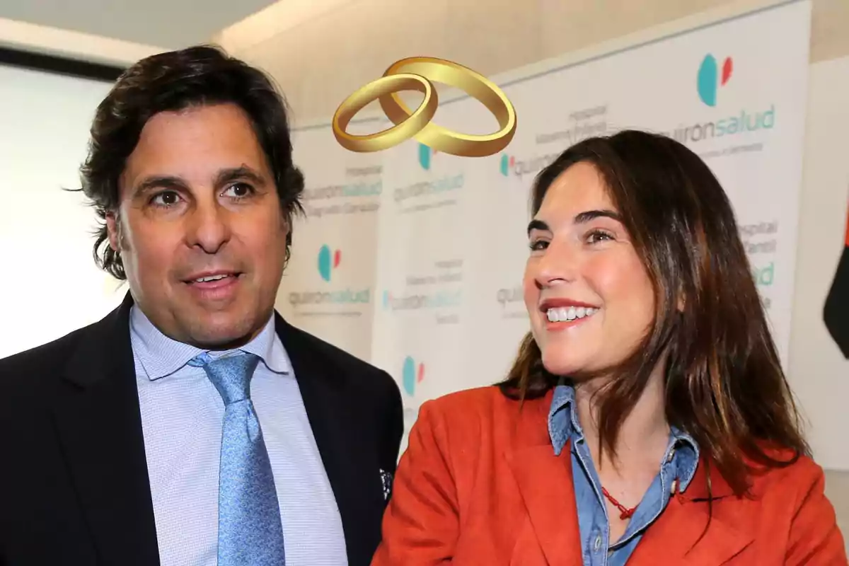 Parella somrient amb anells de casament daurats sobre els seus caps en un esdeveniment de Quirónsalud