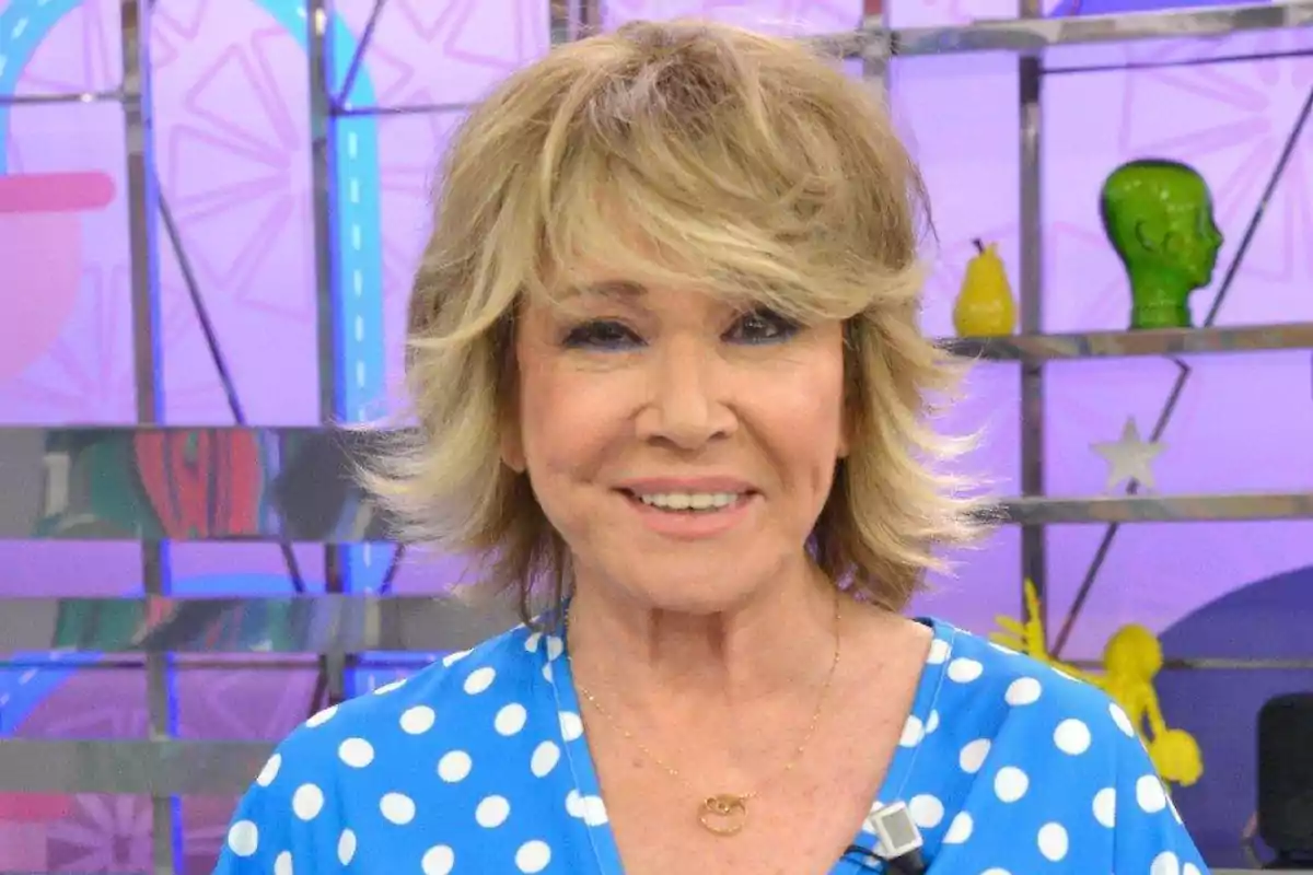 Dona de cabell ros curt amb una brusa blava de punts blancs somrient en un plató de televisió colorit Dona de cabell ros curt amb una brusa blava de punts blancs somrient en un plató de televisió colorit