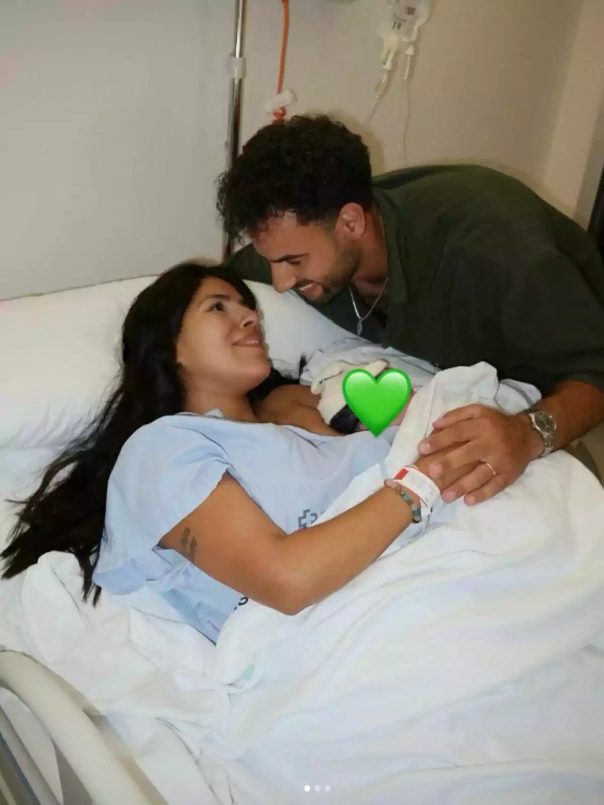 Isa Pantoja estirada en un llit d’hospital somriu mentre Asraf Beno la mira amb tendresa i tots dos es donen la mà, coberts per un llençol blanc. Isa Pantoja estirada en un llit d’hospital somriu mentre Asraf Beno la mira amb tendresa i tots dos es donen la mà, coberts per un llençol blanc.