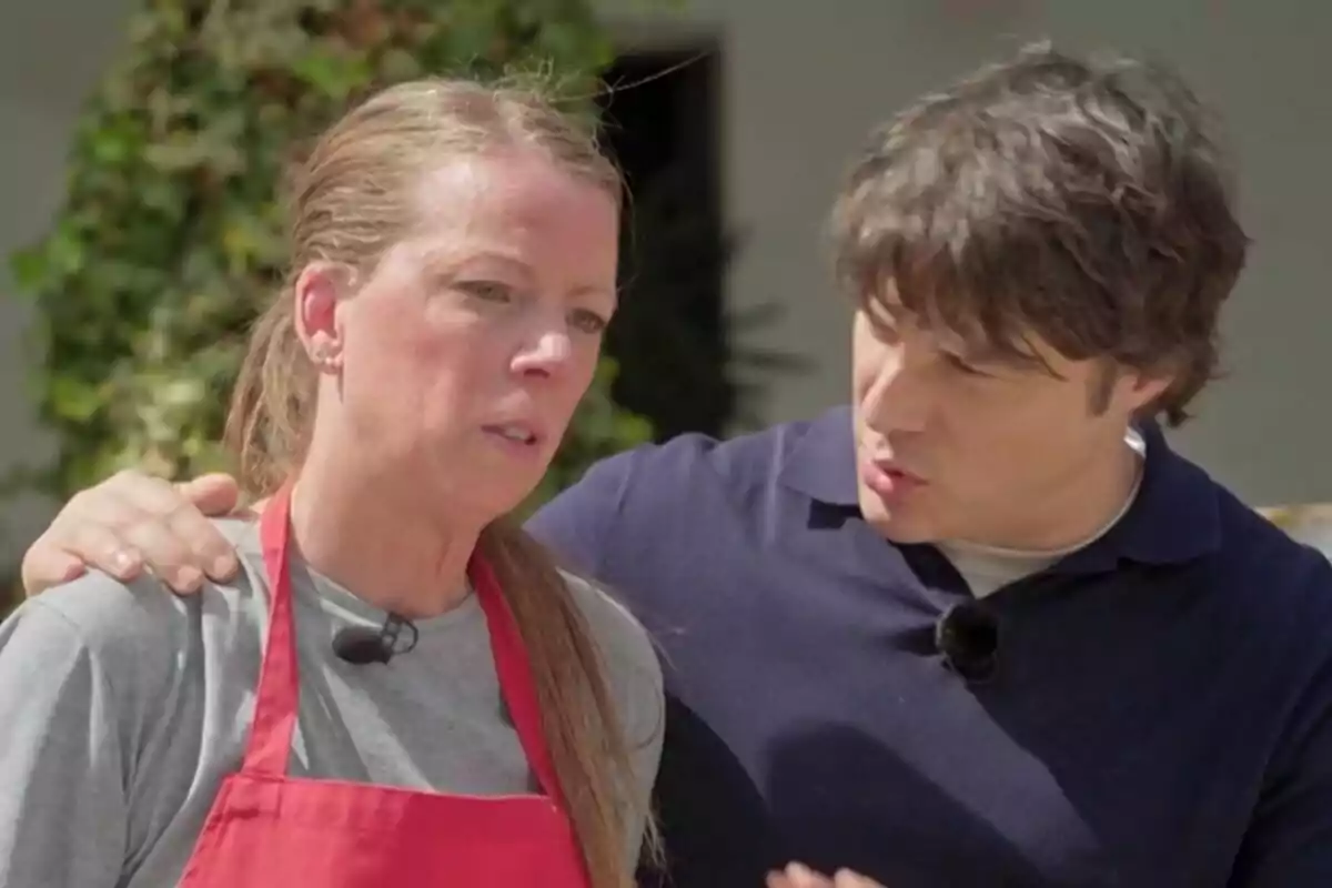 Una concursant de 'MasterChef' amb davantal vermell i expressió seriosa és consolada per Jordi Cruz, que li posa la mà a l'espatlla mentre conversen a l'aire lliure. Una concursant de 'MasterChef' amb davantal vermell i expressió seriosa és consolada per Jordi Cruz, que li posa la mà a l'espatlla mentre conversen a l'aire lliure.