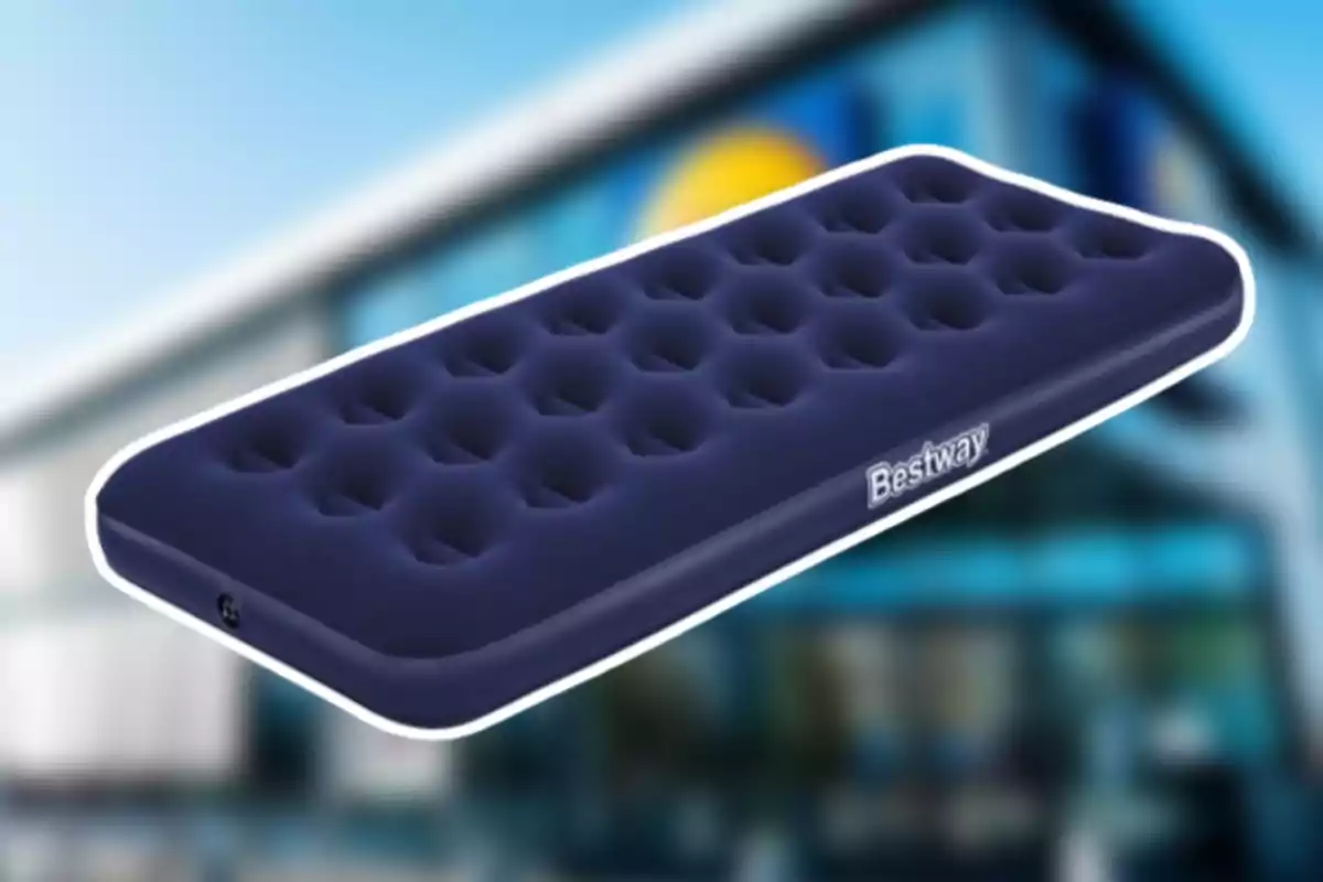 Matalàs inflable blau marí de la marca Bestway sobre un fons desenfocat d’una botiga Matalàs inflable blau marí de la marca Bestway sobre un fons desenfocat d’una botiga