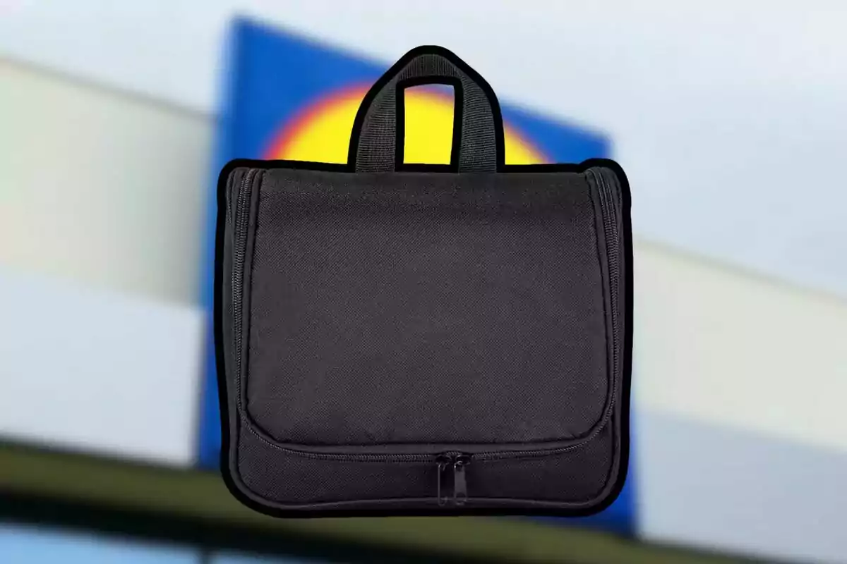 Bossa negra de tela amb tancament i nansa al davant d’un fons desenfocat amb colors blau, groc i vermell. Bossa negra de tela amb tancament i nansa al davant d’un fons desenfocat amb colors blau, groc i vermell.