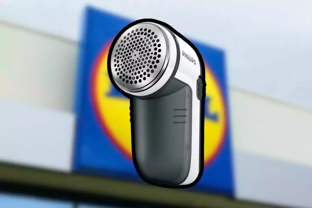 Lleva-pelusses elèctric de la marca Philips amb un fons desenfocat d’un rètol de supermercat Lleva-pelusses elèctric de la marca Philips amb un fons desenfocat d’un rètol de supermercat