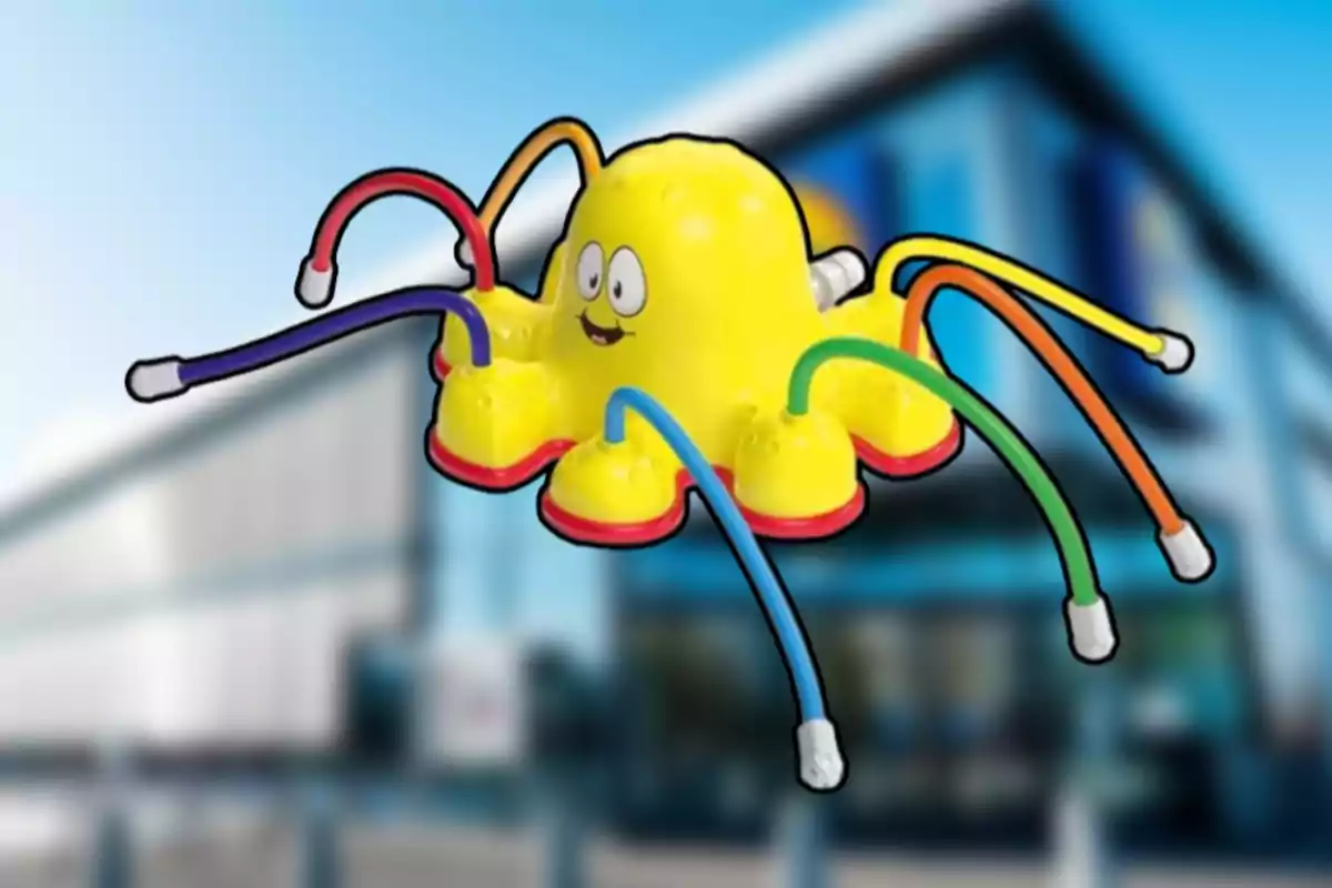 Joguina groga amb forma de pop somrient i tentacles de colors davant d’un edifici desenfocat Joguina groga amb forma de pop somrient i tentacles de colors davant d’un edifici desenfocat