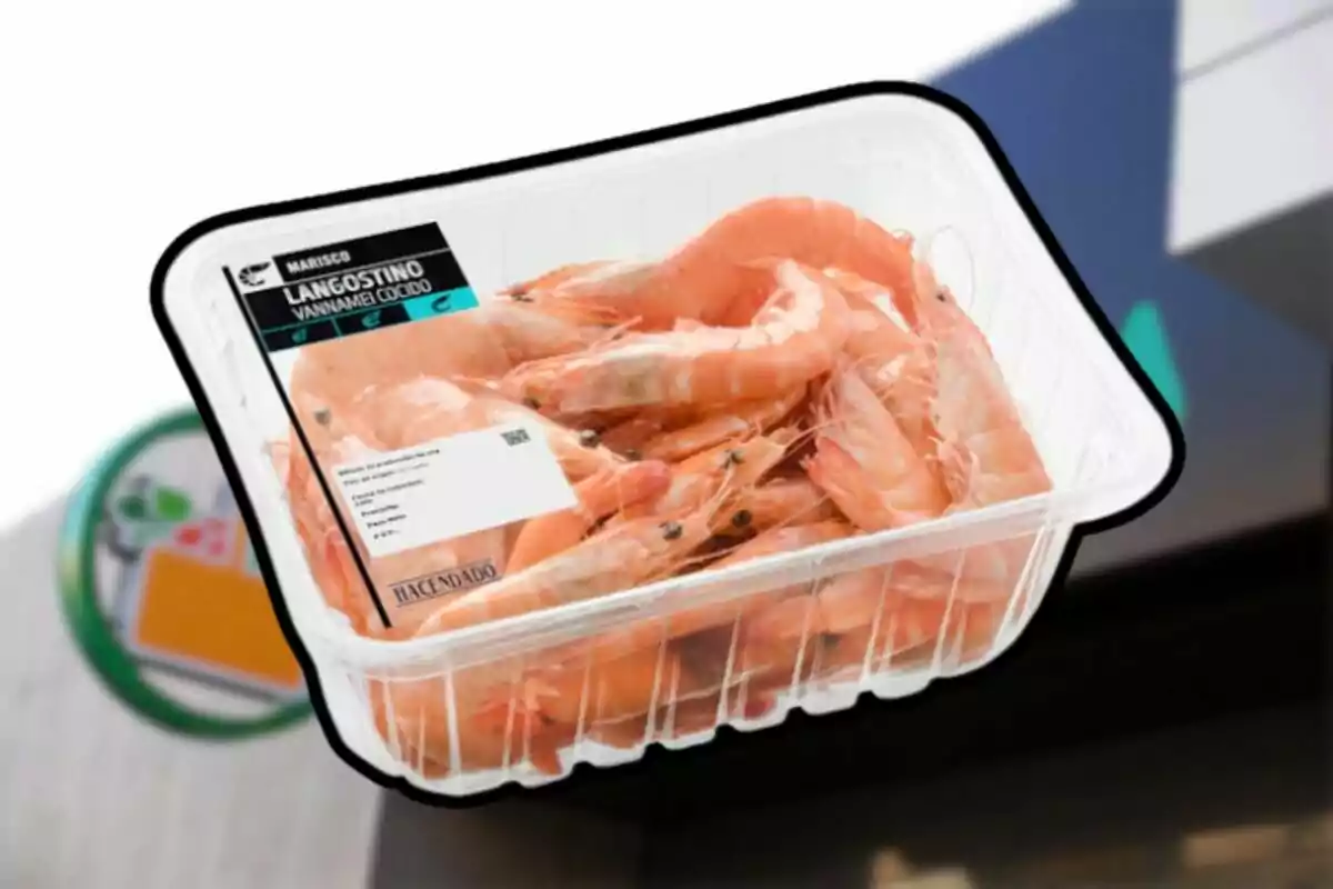 Envàs de llagostins cuits de la marca Hacendado sostingut davant d’un supermercat Envàs de llagostins cuits de la marca Hacendado sostingut davant d’un supermercat