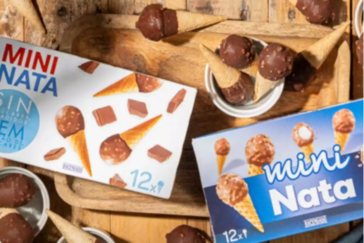 Caixes de gelats mini nata al costat de cucurutxos petits coberts de xocolata sobre una safata de fusta Caixes de gelats mini nata al costat de cucurutxos petits coberts de xocolata sobre una safata de fusta