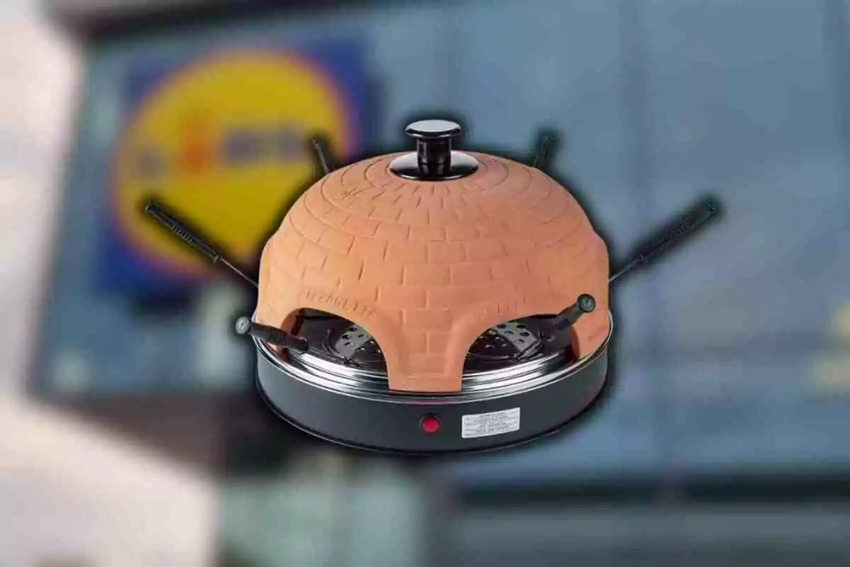 Horno eléctrico con forma de iglú de ladrillo con varias paletas para pizza y fondo desenfocado de una tienda Lidl Horno eléctrico con forma de iglú de ladrillo con varias paletas para pizza y fondo desenfocado de una tienda Lidl