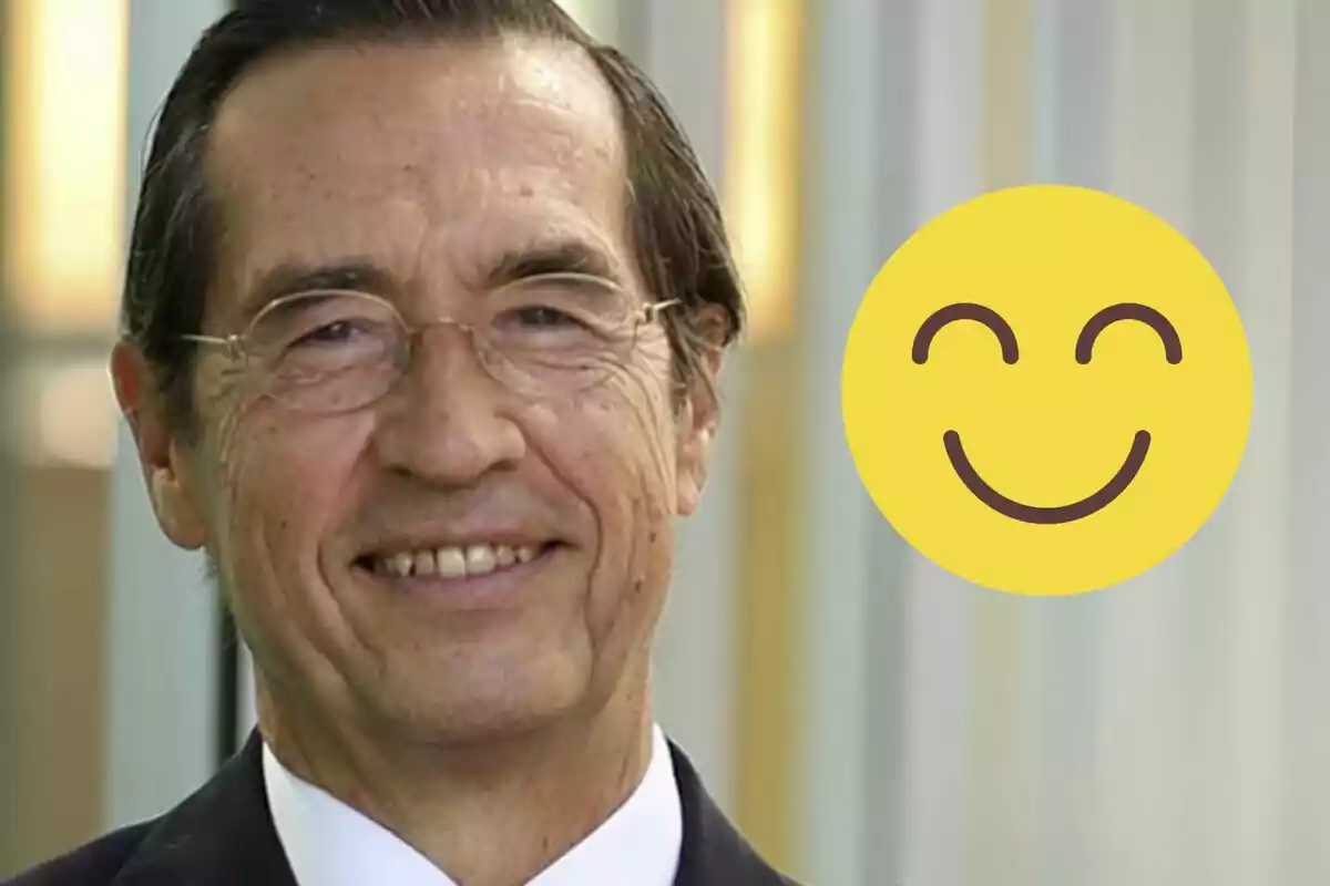 Older man with glasses smiling and a yellow smiling emoji next to him