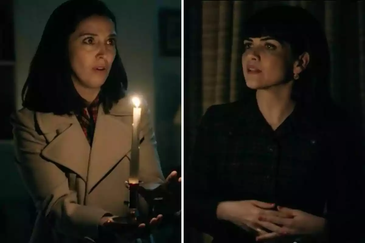Luz i Gema en una habitació fosca, una sosté una espelma encesa i sembla sorpresa, l’altra l’observa amb expressió seriosa. Luz i Gema en una habitació fosca, una sosté una espelma encesa i sembla sorpresa, l’altra l’observa amb expressió seriosa.