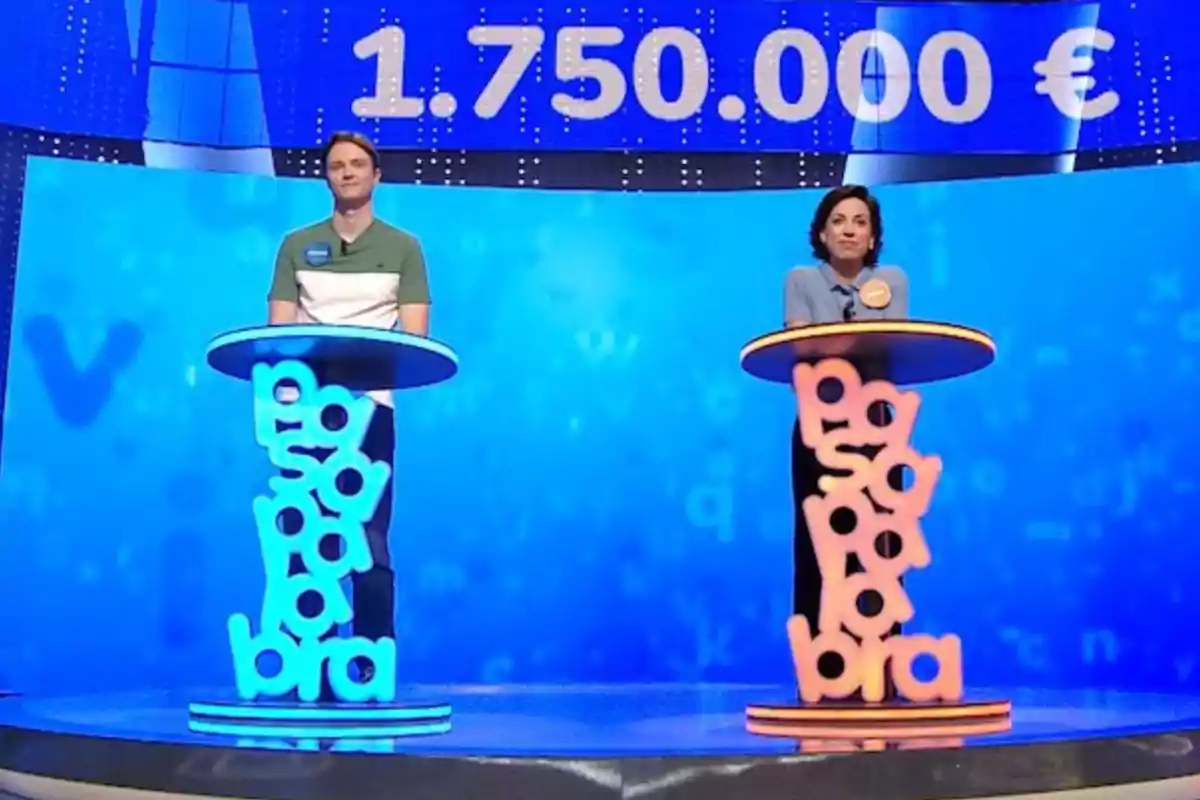 Manu i Rosa drets als seus faristols en un programa de televisió amb un premi d’un milió set-cents cinquanta mil euros mostrat a la pantalla de fons. Captura de ‘Pasapalabra’ Manu i Rosa drets als seus faristols en un programa de televisió amb un premi d’un milió set-cents cinquanta mil euros mostrat a la pantalla de fons. Captura de ‘Pasapalabra’
