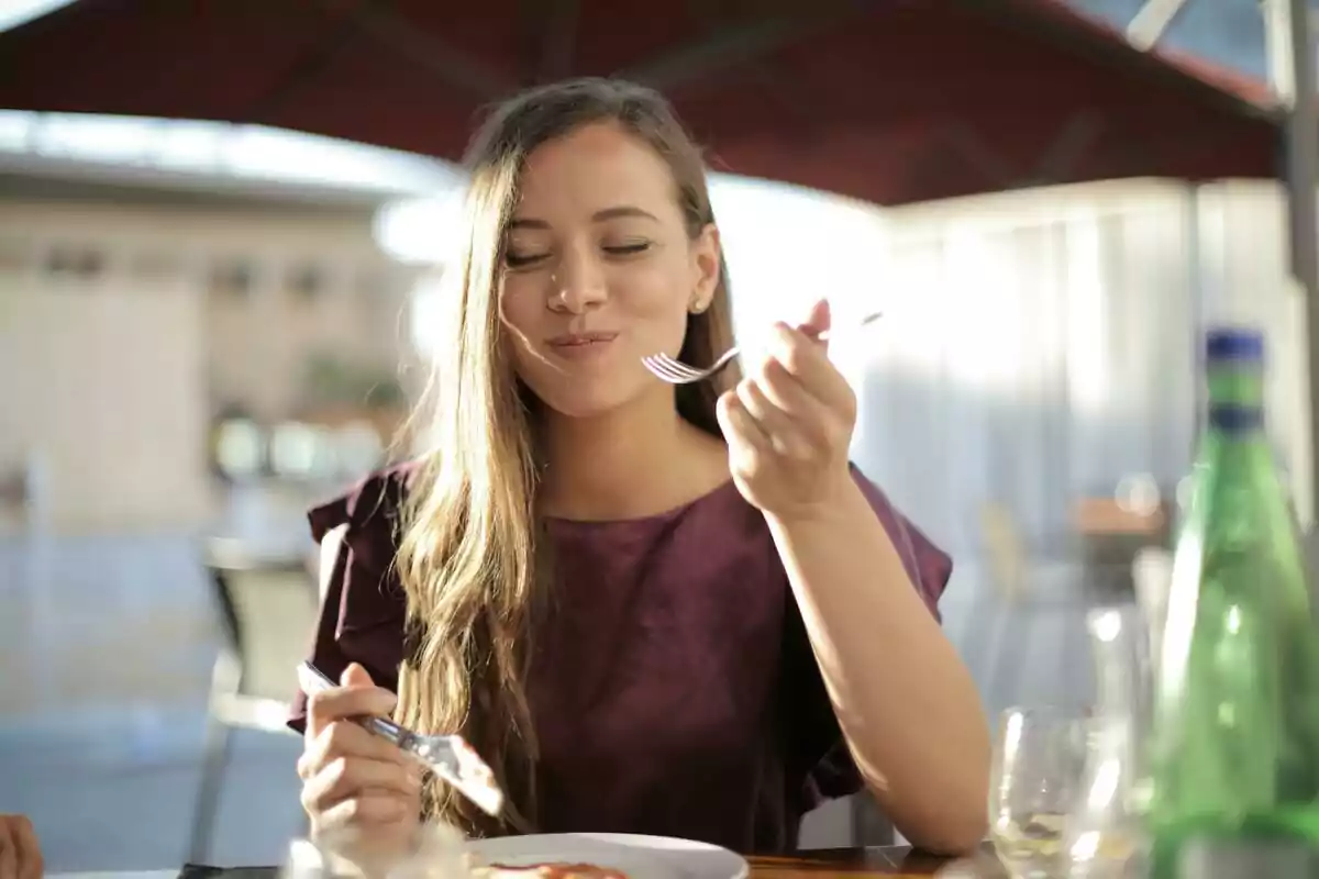 Young woman enjoying a meal at an outdoor restaurant Young woman enjoying a meal at an outdoor restaurant