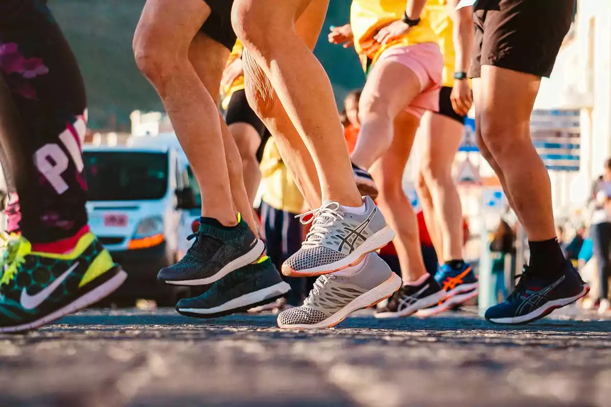 People running in an outdoor race with a focus on their legs and athletic shoes People running in an outdoor race with a focus on their legs and athletic shoes