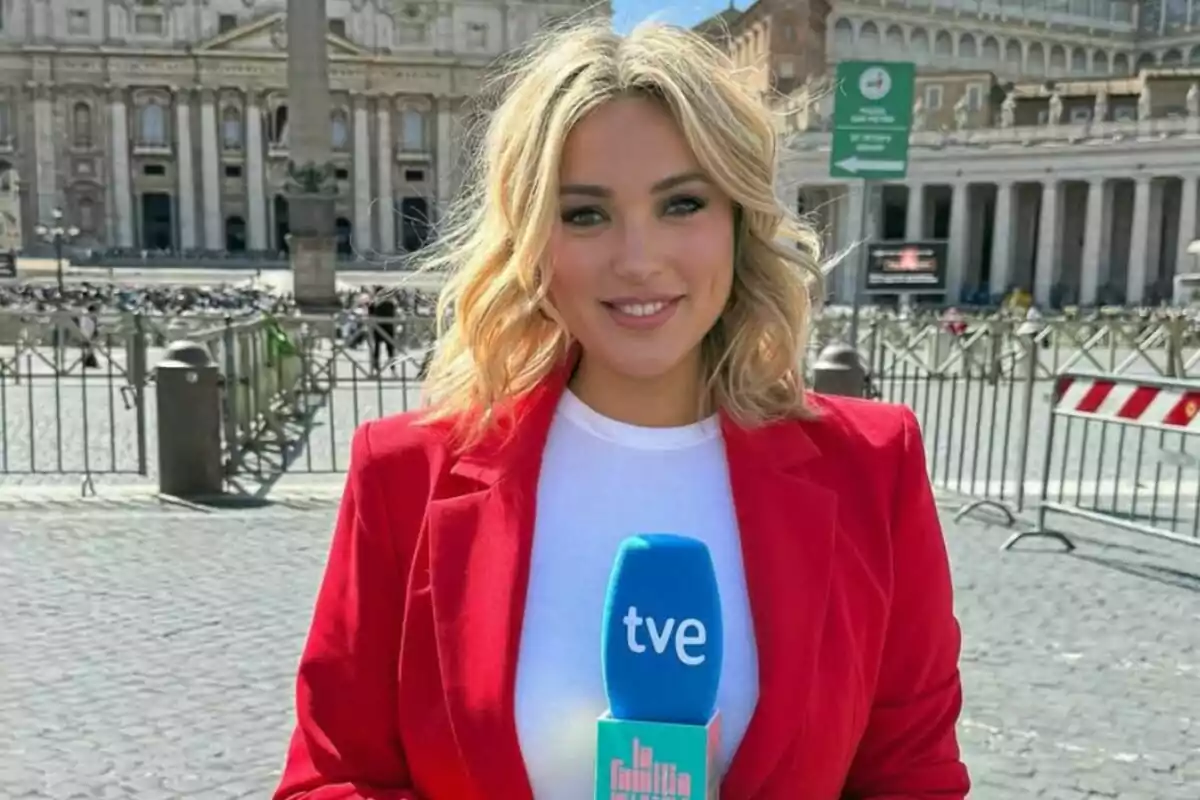 Marta Riesco rossa amb jaqueta vermella sosté un micròfon blau de tve de 'La família de la tele' Marta Riesco rossa amb jaqueta vermella sosté un micròfon blau de tve de 'La família de la tele'