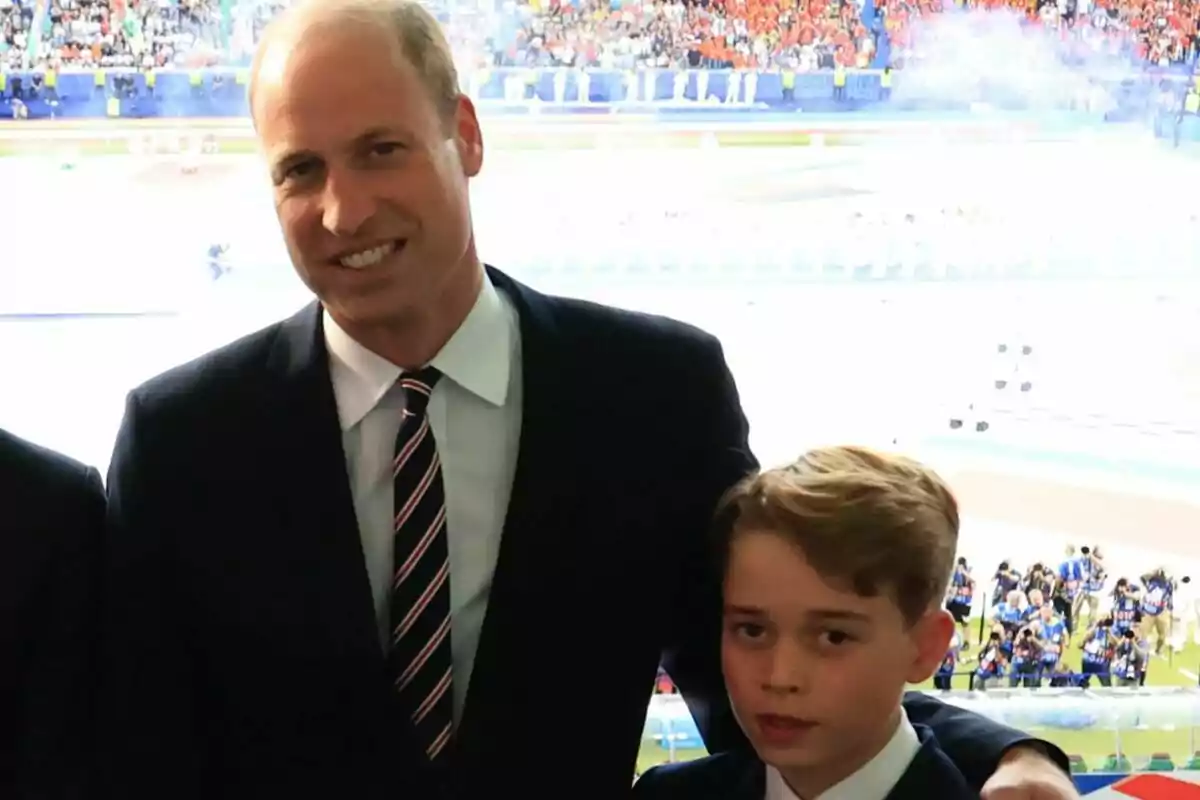 Imagen del príncipe George y el príncipe Guillermo en un estadio lleno de público.