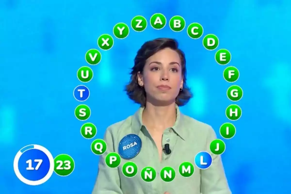 Roas Rodríguez concursant en un programa de televisió amb lletres de l’abecedari en cercle i un marcador de temps i encerts. Roas Rodríguez concursant en un programa de televisió amb lletres de l’abecedari en cercle i un marcador de temps i encerts.