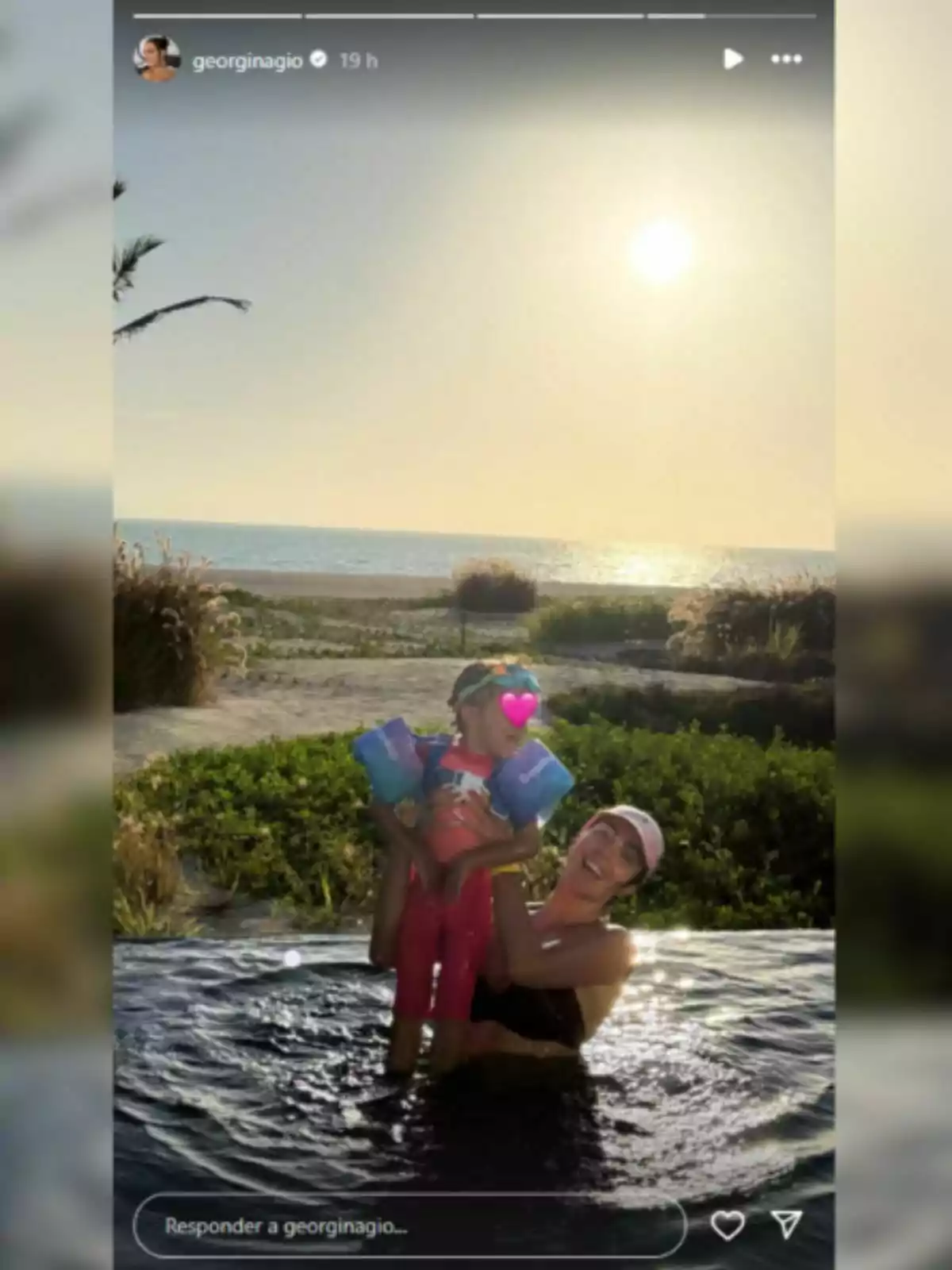 Georgina Rodríguez en una piscina sosté una nena amb flotadors mentre gaudeixen d’una posta de sol davant del mar. Georgina Rodríguez en una piscina sosté una nena amb flotadors mentre gaudeixen d’una posta de sol davant del mar.