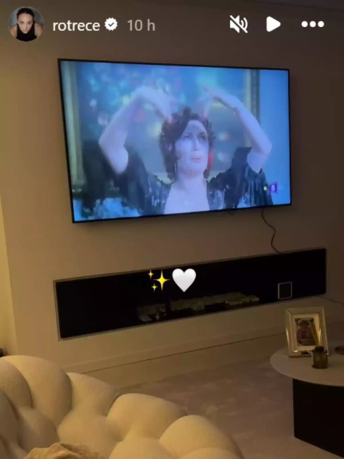 Story de Rocío Flores on es veu una sala d'estar moderna amb un televisor encès que mostra la Rocío Jurado ballant i cantant Story de Rocío Flores on es veu una sala d'estar moderna amb un televisor encès que mostra la Rocío Jurado ballant i cantant