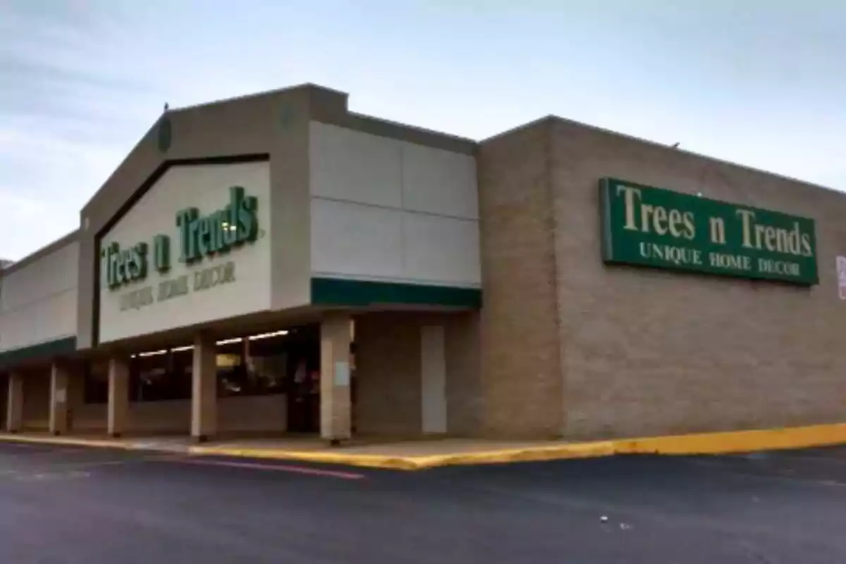 Storefront of a shop called Trees n Trends specializing in home decor, with green signs and brick walls. Storefront of a shop called Trees n Trends specializing in home decor, with green signs and brick walls.