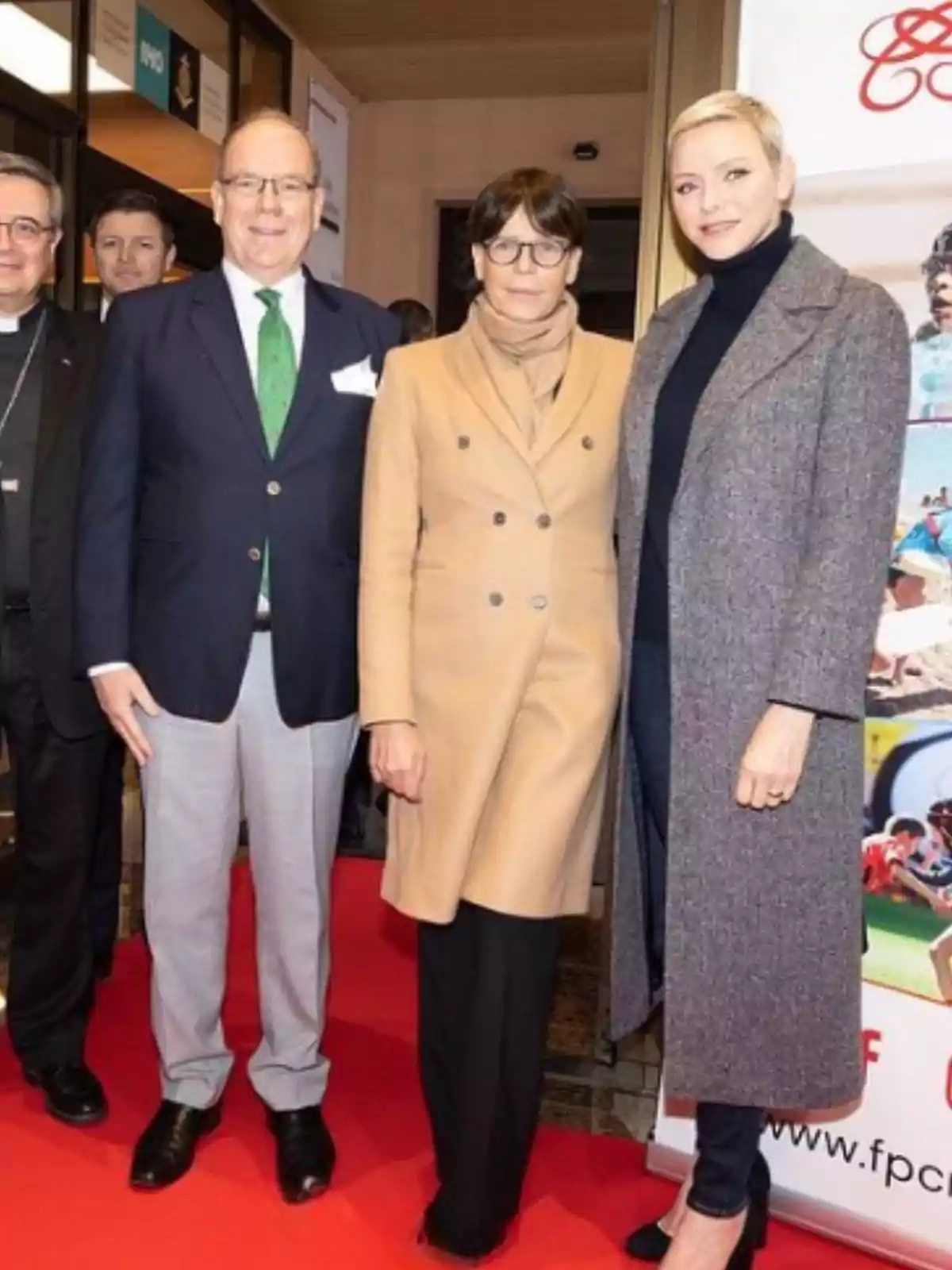 Tres personas posan sobre una alfombra roja en un evento formal, dos mujeres y un hombre, todos vestidos elegantemente y sonriendo a la cámara Tres personas posan sobre una alfombra roja en un evento formal, dos mujeres y un hombre, todos vestidos elegantemente y sonriendo a la cámara