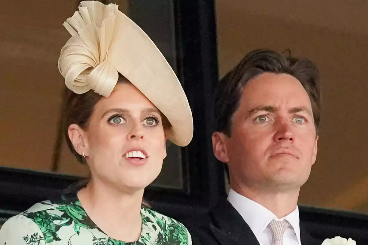Beatriz de York amb barret elegant i vestit floral al costat d’Edoardo Mapelli amb vestit i corbata observant alguna cosa amb atenció Beatriz de York amb barret elegant i vestit floral al costat d’Edoardo Mapelli amb vestit i corbata observant alguna cosa amb atenció