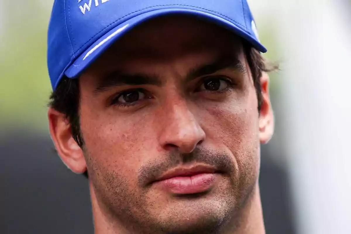 Primer pla de Carlos Sainz amb gorra blava mirant cap a la càmera. Primer pla de Carlos Sainz amb gorra blava mirant cap a la càmera.