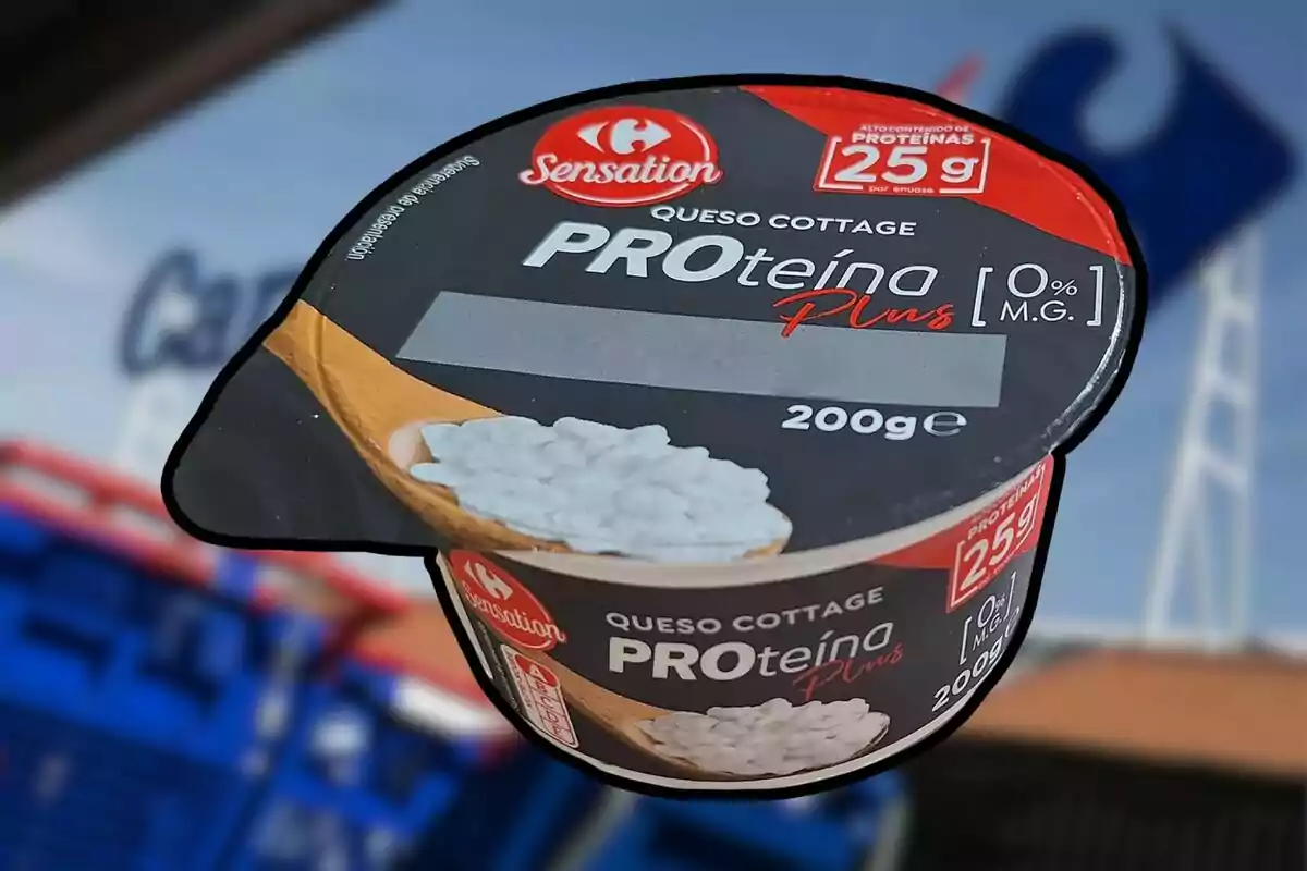 Envàs de formatge cottage PROteïna Plus de 200 grams de la marca Sensation sostingut davant d’un fons desenfocat d’una botiga Carrefour Envàs de formatge cottage PROteïna Plus de 200 grams de la marca Sensation sostingut davant d’un fons desenfocat d’una botiga Carrefour