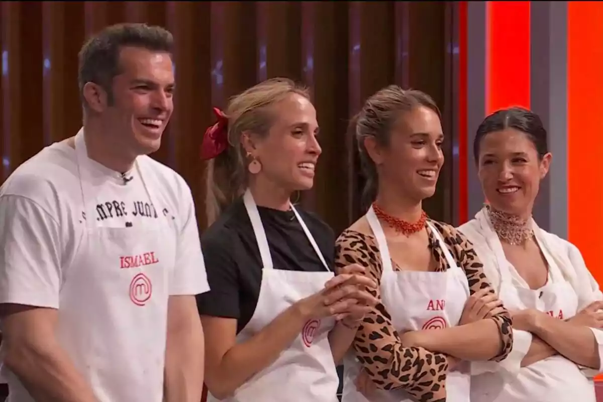Quatre persones —que són concursants de 'MasterChef' 2025— somriuen i porten davantals blancs de cuina en un plató de concurs. Quatre persones —que són concursants de 'MasterChef' 2025— somriuen i porten davantals blancs de cuina en un plató de concurs.