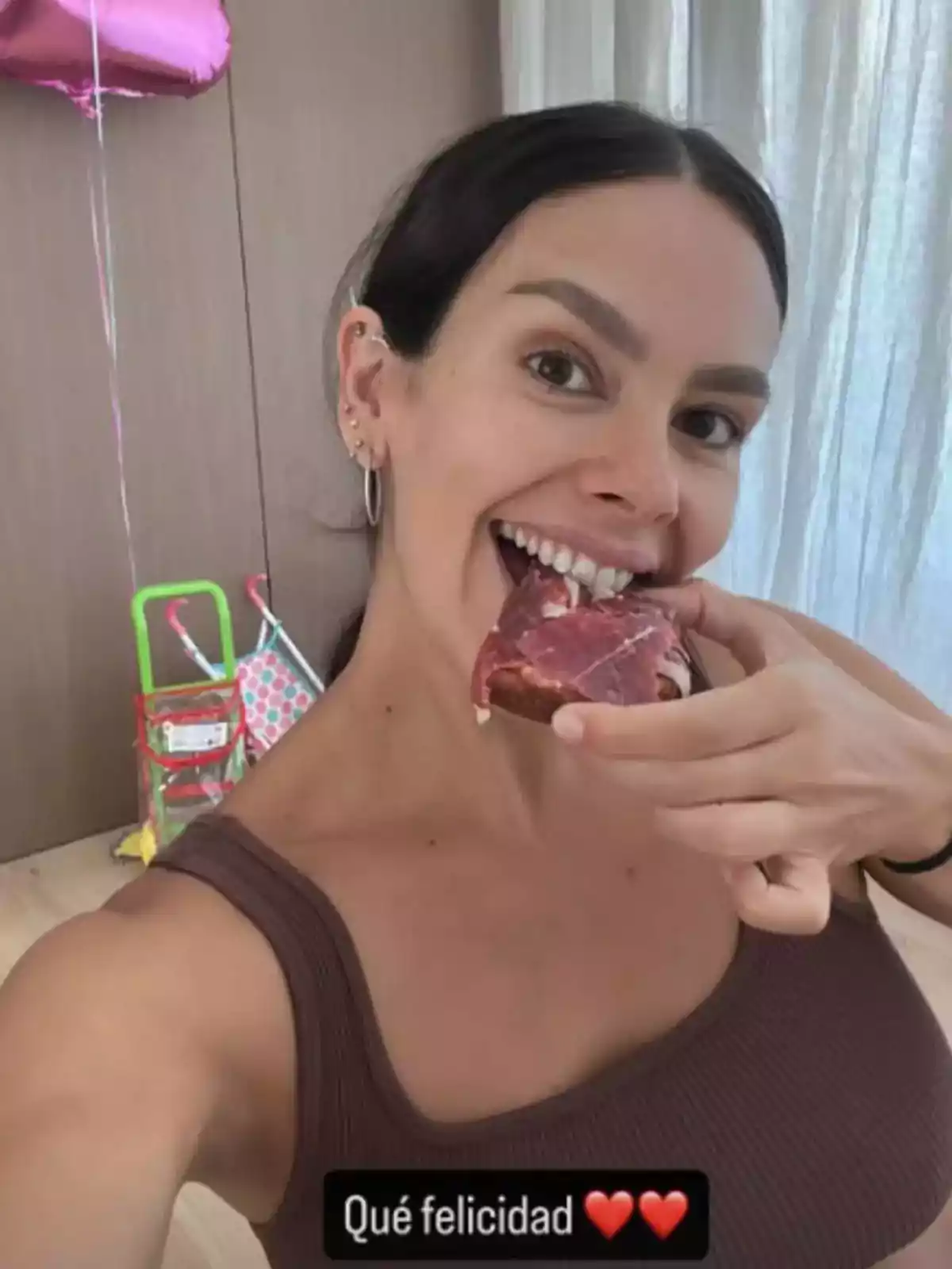 Cristina Pedroche sonriente tomando una selfie mientras muerde una rebanada de pan con jamón, al fondo se ven globos y un carrito de juguete, con la frase: Qué felicidad y dos corazones rojos Cristina Pedroche sonriente tomando una selfie mientras muerde una rebanada de pan con jamón, al fondo se ven globos y un carrito de juguete, con la frase: Qué felicidad y dos corazones rojos