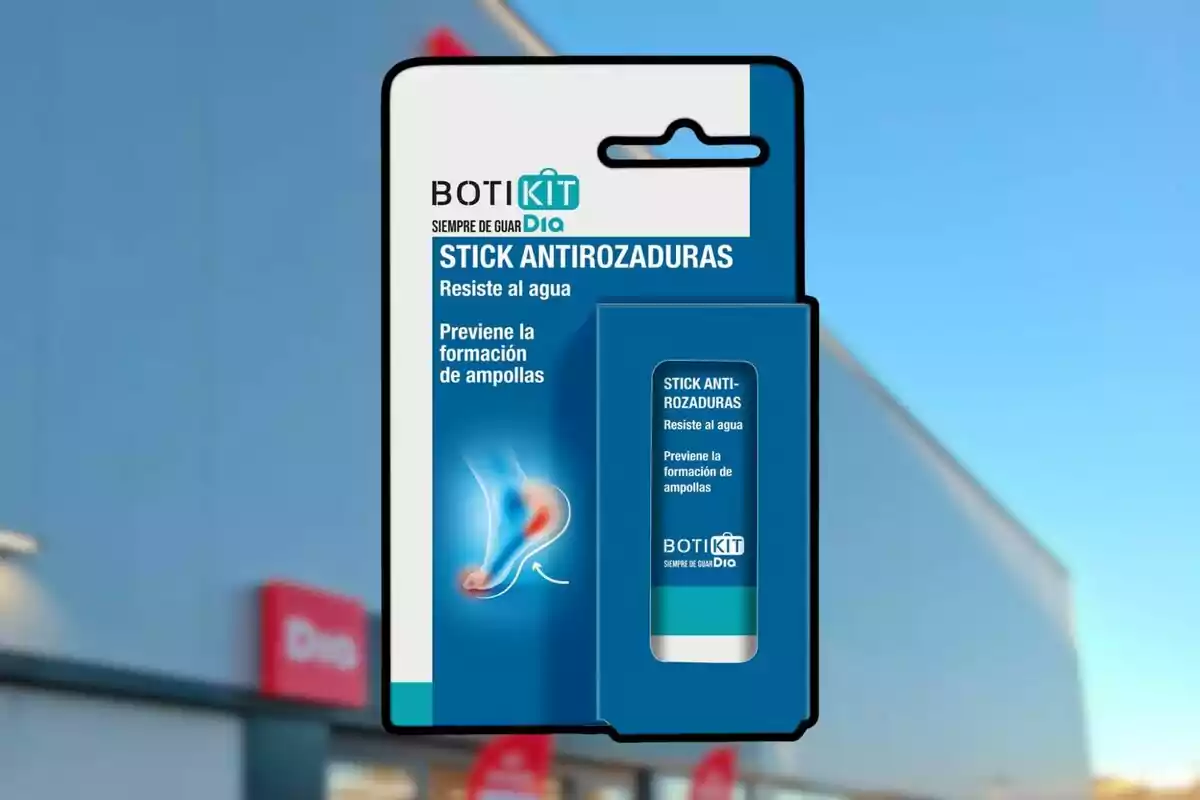 Envàs de stick anti-raspadures de la marca Botikit Dia sostingut davant d’una botiga amb el logotip de Dia desenfocat al fons Envàs de stick anti-raspadures de la marca Botikit Dia sostingut davant d’una botiga amb el logotip de Dia desenfocat al fons