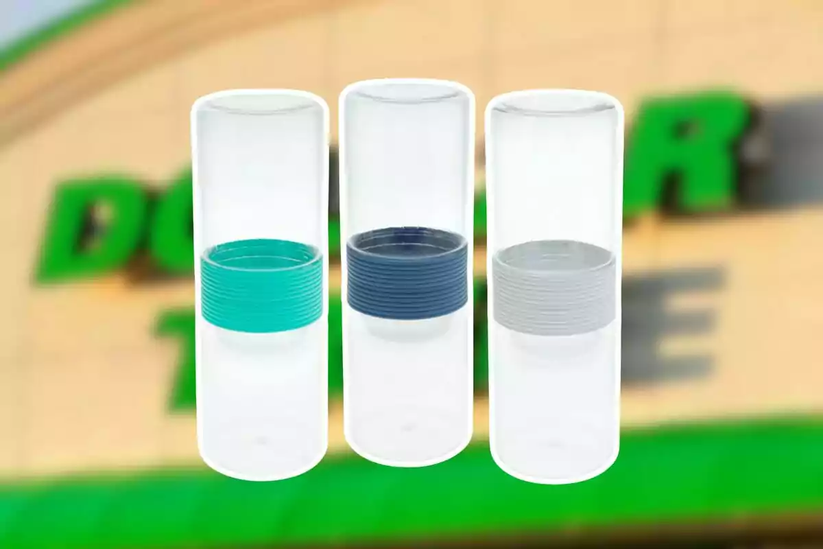 Tres botellas de plástico transparentes con bandas de colores en el centro una verde una azul y una gris sobre un fondo desenfocado de una tienda Tres botellas de plástico transparentes con bandas de colores en el centro una verde una azul y una gris sobre un fondo desenfocado de una tienda