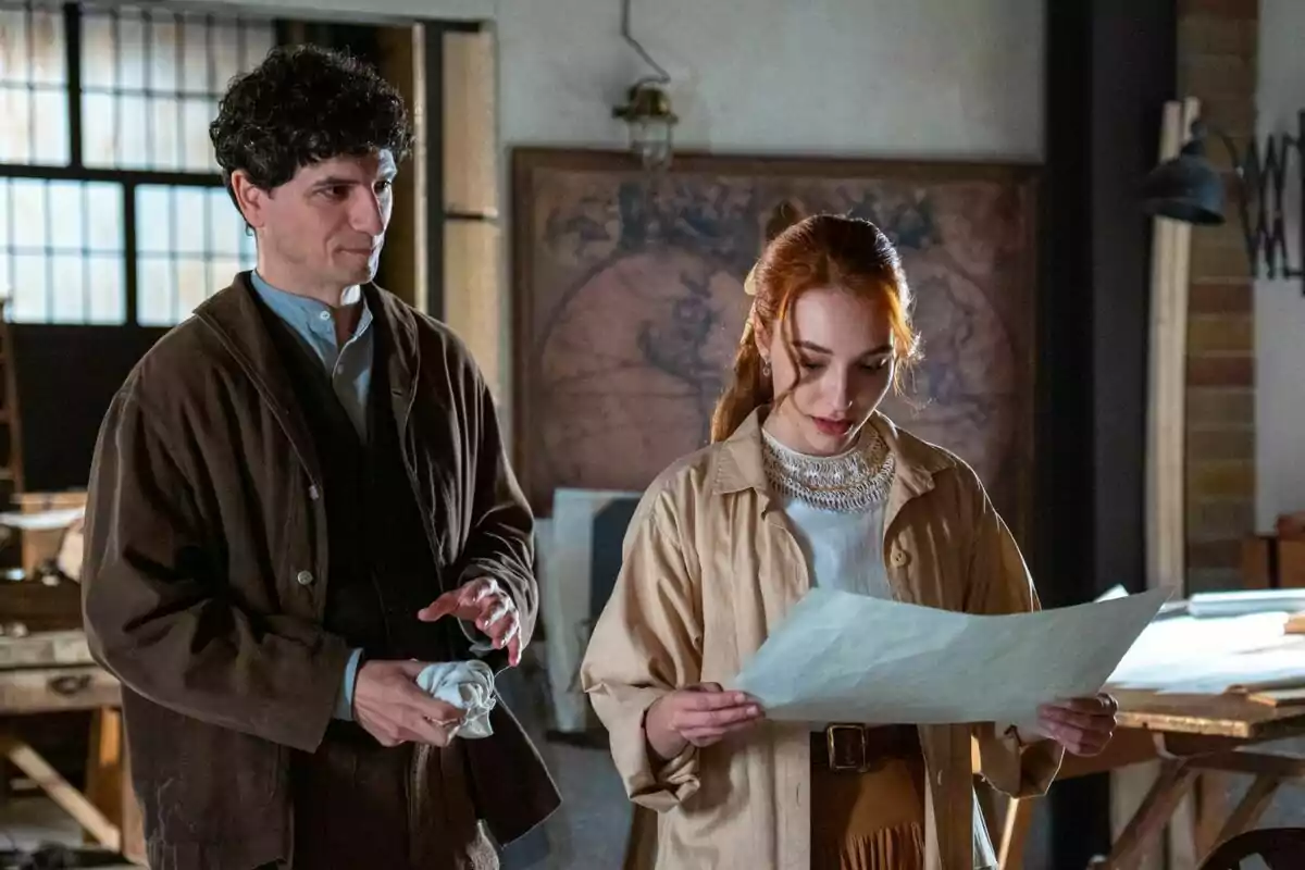 Two people in a room with natural light, a woman looks at a piece of paper while a man watches her and holds a handkerchief; he is Álvaro Quintana and she is the actress Sara Font. Two people in a room with natural light, a woman looks at a piece of paper while a man watches her and holds a handkerchief; he is Álvaro Quintana and she is the actress Sara Font.