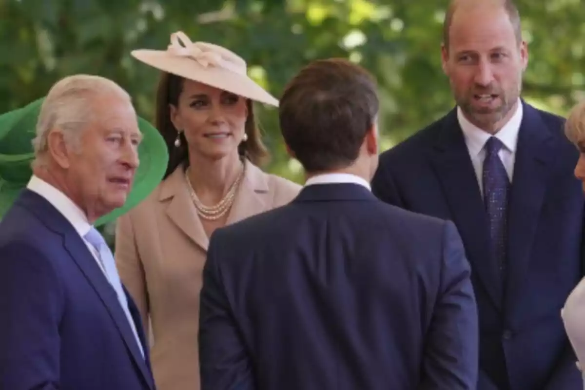 Varias personas elegantemente vestidas conversan al aire libre en un evento formal, las cuales son la Familia Real británica junto a Emmanuel Macron. Varias personas elegantemente vestidas conversan al aire libre en un evento formal, las cuales son la Familia Real británica junto a Emmanuel Macron.